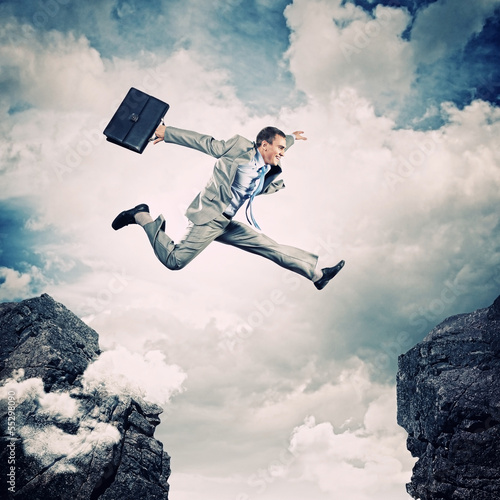 Photo: Businessman jumping over gap Businessman jumping over gap