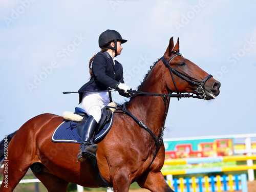 Photo: The sportswoman on a red horse at competitions. The sportswoman on a red horse at competitions.
