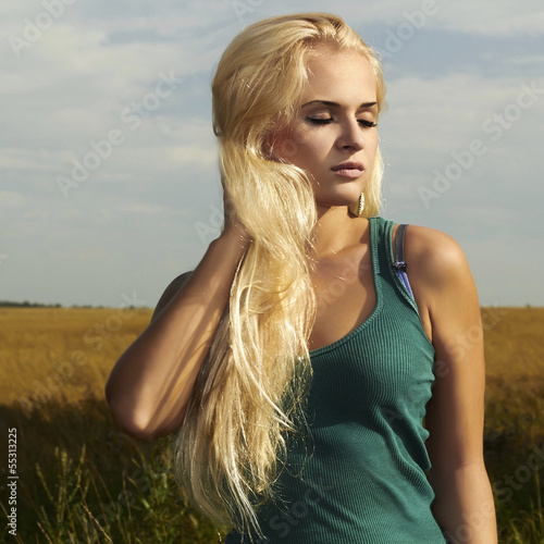 Photo: Beautiful blond girl on the field.beauty woman.nature Beautiful blond girl on the field.beauty woman.nature