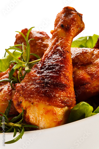 Photo: Grilled chicken legs and vegetables on white background Grilled chicken legs and vegetables on white background