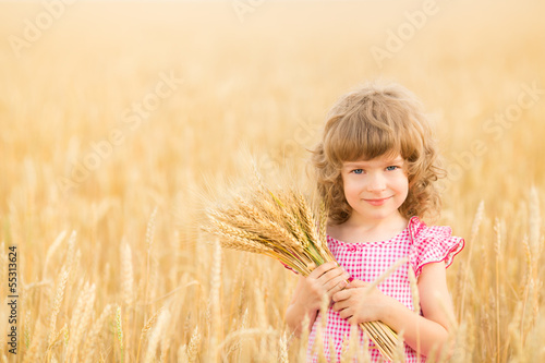 Photo: Happy child holding wheat ears Happy child holding wheat ears