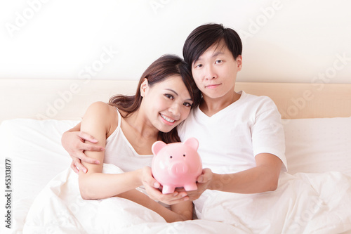 Photo: happy couple with pink piggy bank happy couple with pink piggy bank
