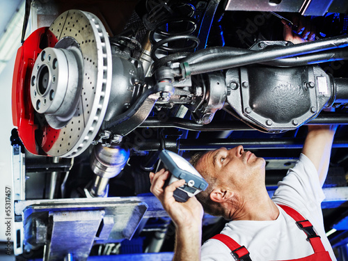 Photo: Motor mechanic inspecting the engine of a car Motor mechanic inspecting the engine of a car
