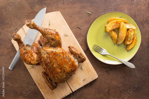 Photo: Whole roast chicken on wooden table Whole roast chicken on wooden table