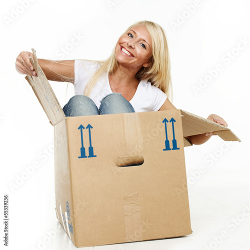 Photo: Pretty young woman stting in her moving box Pretty young woman stting in her moving box