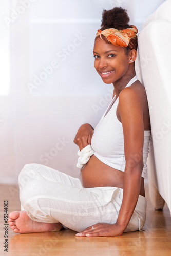 Photo: Young pregnant black woman touching her belly - African people Young pregnant black woman touching her belly - African people