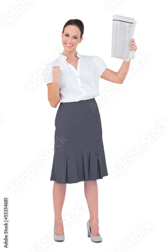 Photo: Victorious stylish businesswoman holding newspaper Victorious stylish businesswoman holding newspaper