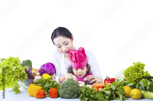 Photo: Asian mother teach daughter cook - isolated Asian mother teach daughter cook - isolated