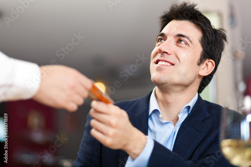 Photo: Man paying with credit card at the restaurant Man paying with credit card at the restaurant