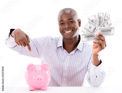 Photo: Man saving money in a piggybank Man saving money in a piggybank
