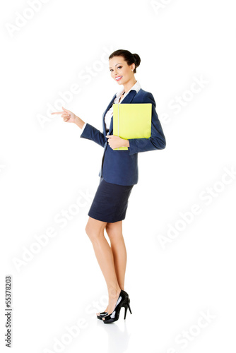 Photo: Happy young success business woman pointing on copy space Happy young success business woman pointing on copy space