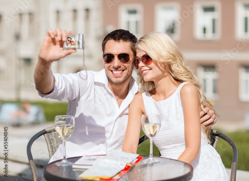 Photo: couple taking photo in cafe couple taking photo in cafe