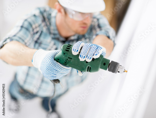 Photo: man drilling the wall man drilling the wall