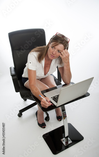 Photo: Stressed female office worker and computer Stressed female office worker and computer