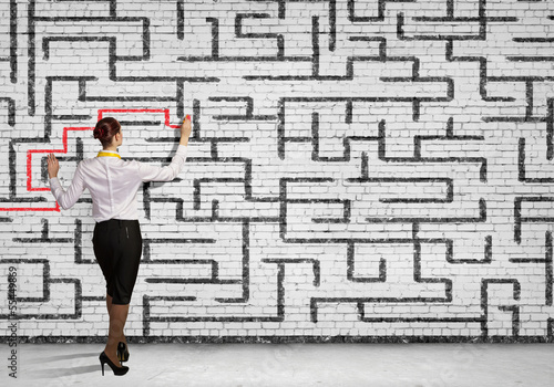 Photo: Businesswoman solving maze problem Businesswoman solving maze problem