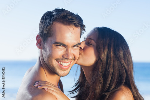 Photo: Attractive woman kissing her boyfriend on the cheek Attractive woman kissing her boyfriend on the cheek