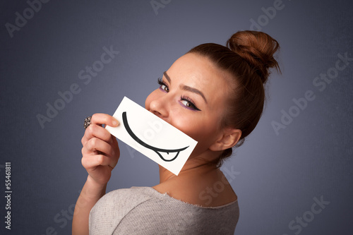 Photo: Pretty young girl holding white card with smile drawing Pretty young girl holding white card with smile drawing
