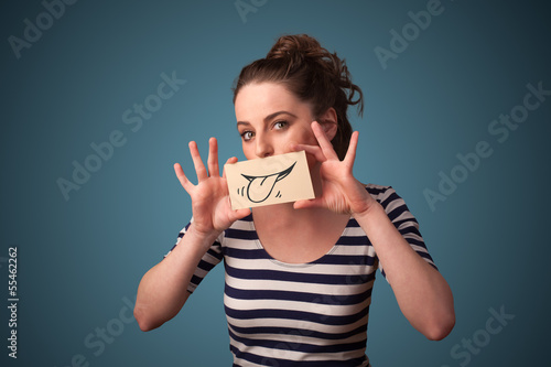 Photo: Pretty young girl holding white card with smile drawing Pretty young girl holding white card with smile drawing