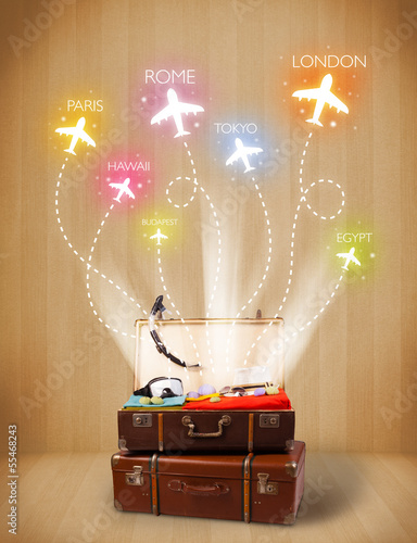 Photo: Travel bag with clothes and colorful planes flying out Travel bag with clothes and colorful planes flying out