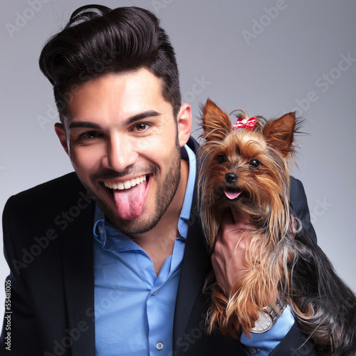 Photo: casual young man holds puppy and pants casual young man holds puppy and pants