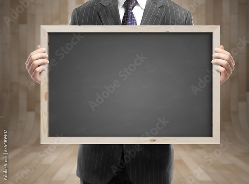 Photo: businessman holding blackboard businessman holding blackboard