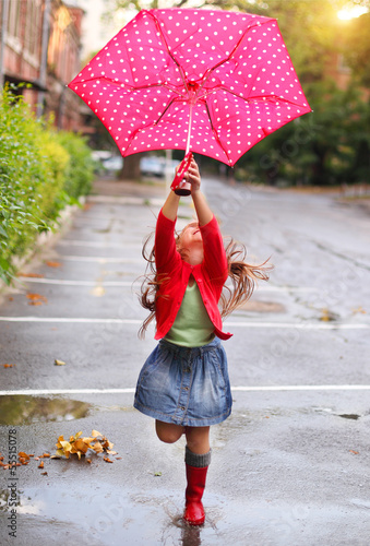 Photo: Child with polka dots umbrella wearing red rain boots Child with polka dots umbrella wearing red rain boots