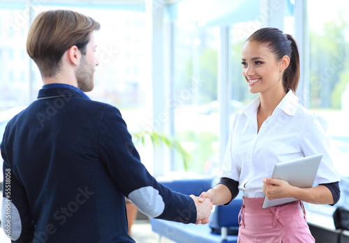 Photo: Cheerful businesspeople, or businesswoman and client handshaking Cheerful businesspeople, or businesswoman and client handshaking