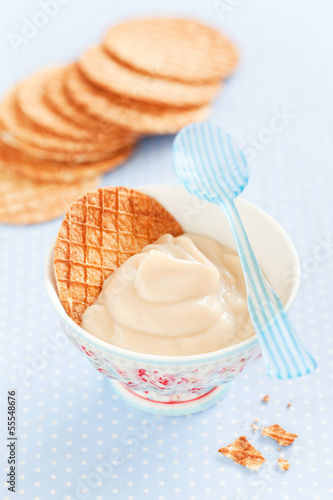 Photo: Caramel cream in a ceramic bowl and waffles, selective focus Caramel cream in a ceramic bowl and waffles, selective focus