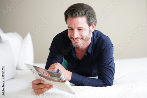 Photo: Mann liest im Bett Mann liest im Bett