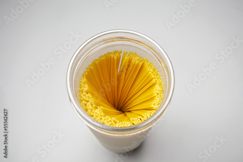 Photo: Top view of raw spaghetti swirl in a glass jar isolated in gray Top view of raw spaghetti swirl in a glass jar isolated in gray