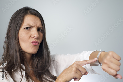 Photo: woman tapping on wrist watch woman tapping on wrist watch