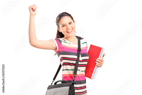 Photo: Happy female student holding notebooks Happy female student holding notebooks