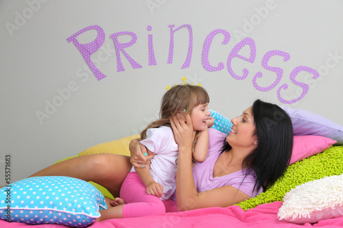 Photo: Little girl with mom lying Little girl with mom lying