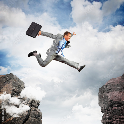 Photo: Businessman jumping over gap Businessman jumping over gap