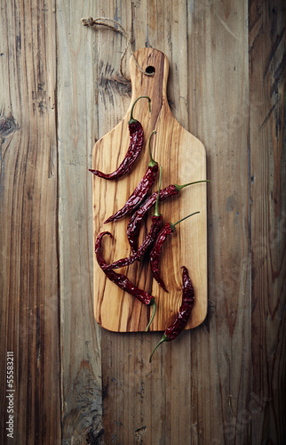 Photo: Dried chili peppers on wooden kitchen board Dried chili peppers on wooden kitchen board