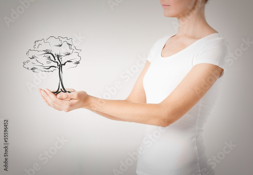 Photo: woman with small tree in her hands woman with small tree in her hands