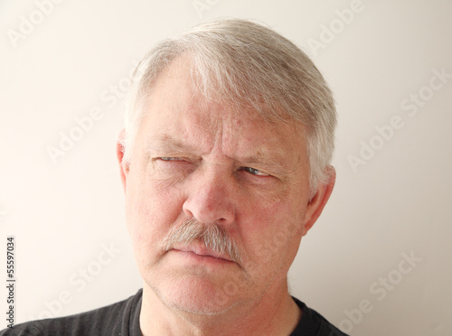 Photo: older man has a distrusting look older man has a distrusting look
