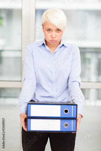 Photo: Tired woman with heavy binders in her hands Tired woman with heavy binders in her hands