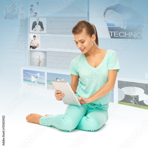 Photo: young girl sitting on the floor with tablet pc young girl sitting on the floor with tablet pc