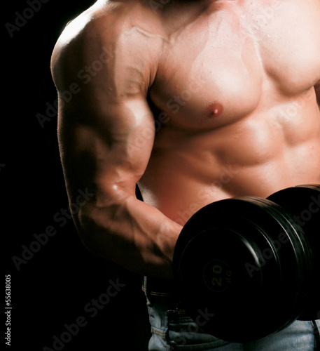 Photo: Handsome muscular man working out with dumbbells Handsome muscular man working out with dumbbells