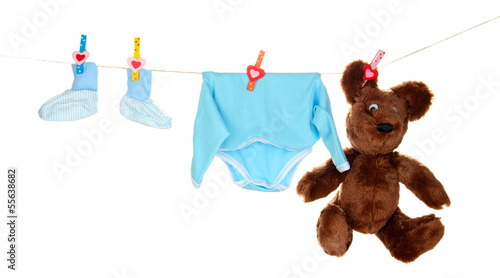 Photo: Baby clothes hanging on clothesline, isolated on white Baby clothes hanging on clothesline, isolated on white