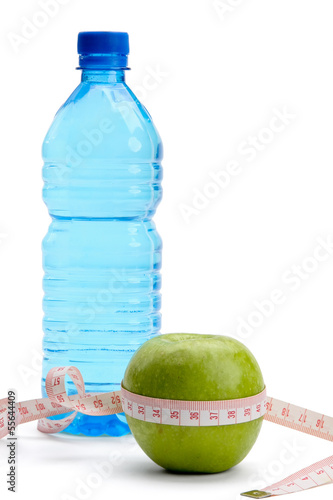 Photo: A green apple, a bottle of water and a measuring tape A green apple, a bottle of water and a measuring tape
