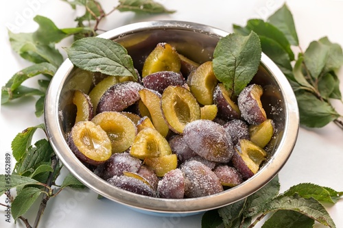 Photo: Bowl halved plums sprinkled with sugar Bowl halved plums sprinkled with sugar