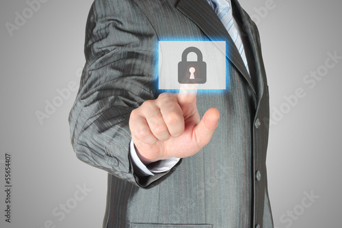 Photo: Businessman pushing virtual security button on grey background. Businessman pushing virtual security button on grey background.