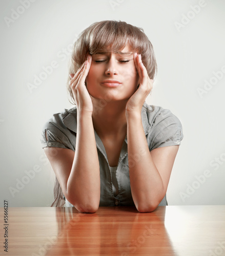Photo: A young tired woman sitting at the desk A young tired woman sitting at the desk