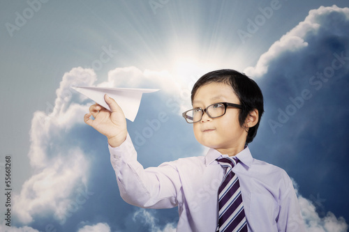 Photo: Little businessman with paper plane outdoor Little businessman with paper plane outdoor