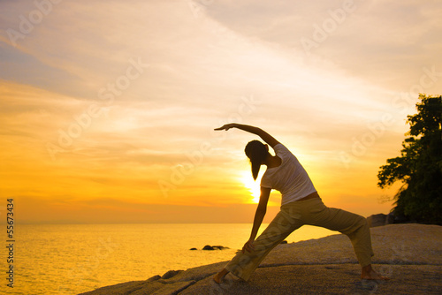 Photo: silhouette of a girl performing yoga on beach sunset silhouette of a girl performing yoga on beach sunset