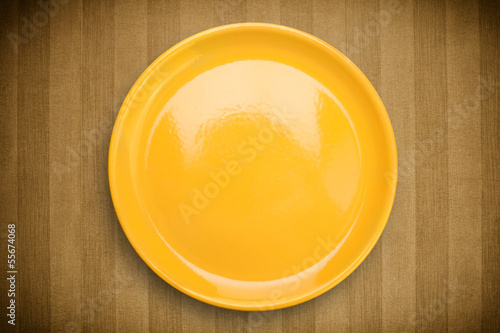 Photo: Colorful empty plate on grungy background table Colorful empty plate on grungy background table