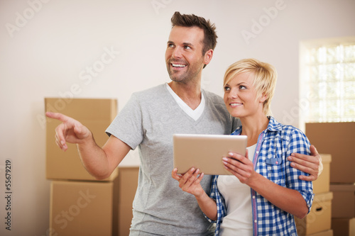 Photo: Couple arranging their house after moving in Couple arranging their house after moving in