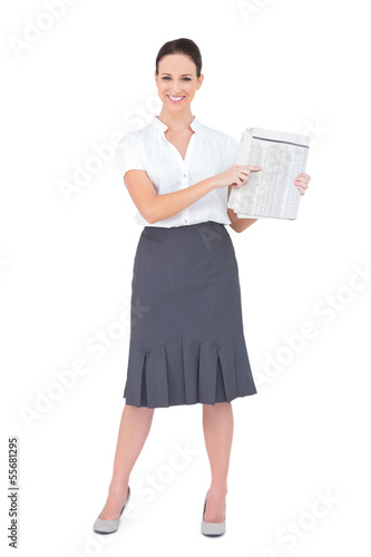 Photo: Happy classy businesswoman holding newspaper Happy classy businesswoman holding newspaper